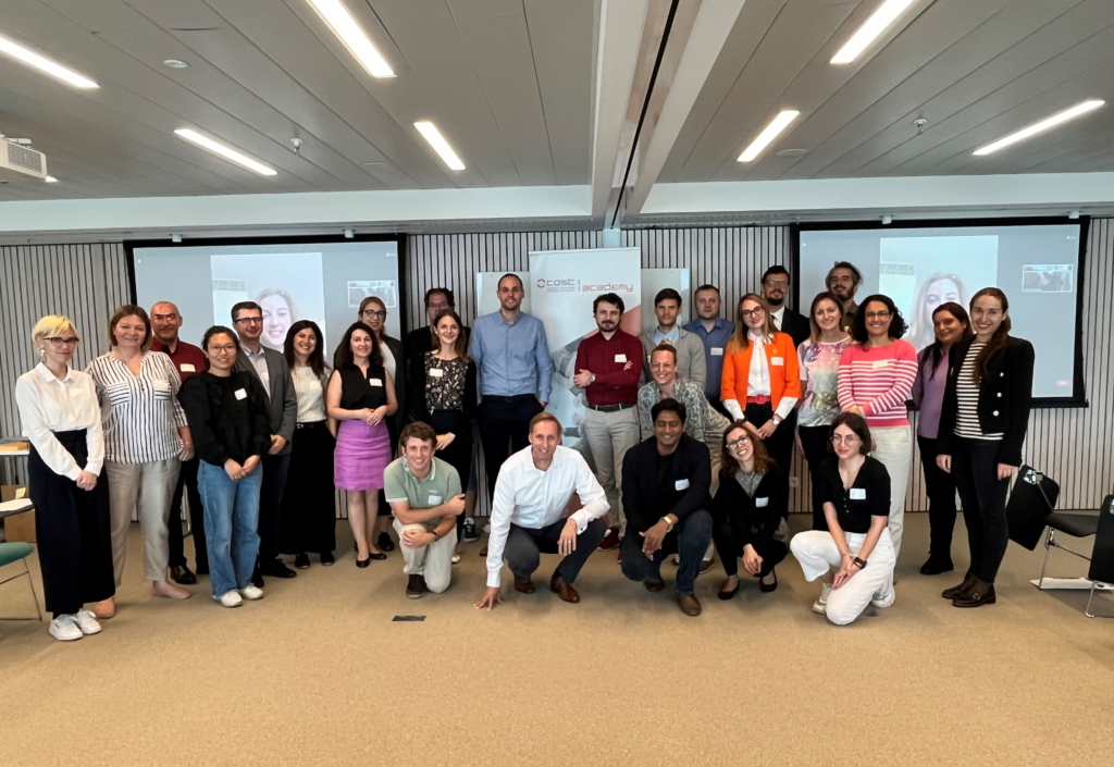 30 men and women posing for a group photo in an office setting